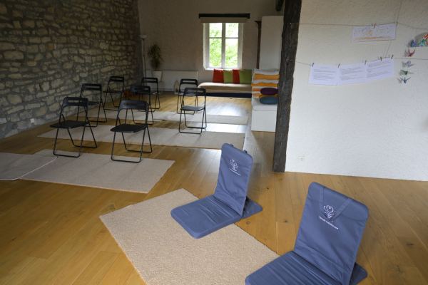 Des assises de méditation posées sur des tapis dans la salle d'activités
